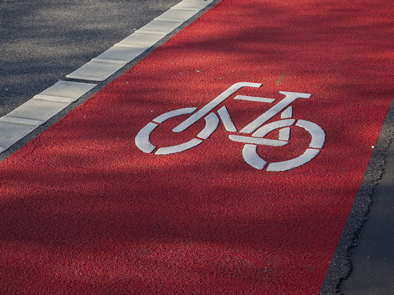 Bicycle path on asphalt in the color red through the use of Lucolor