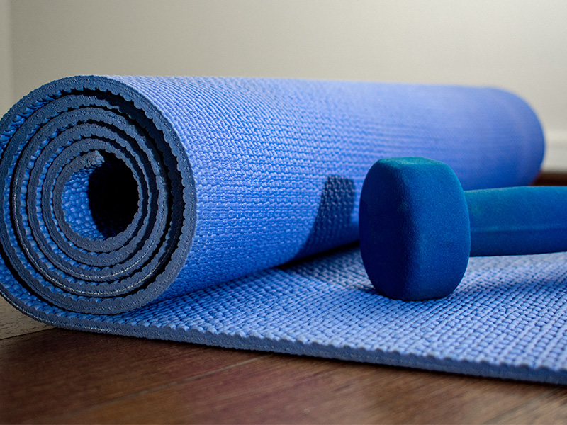 Sports mat half rolled out with a dumbbell lying on it