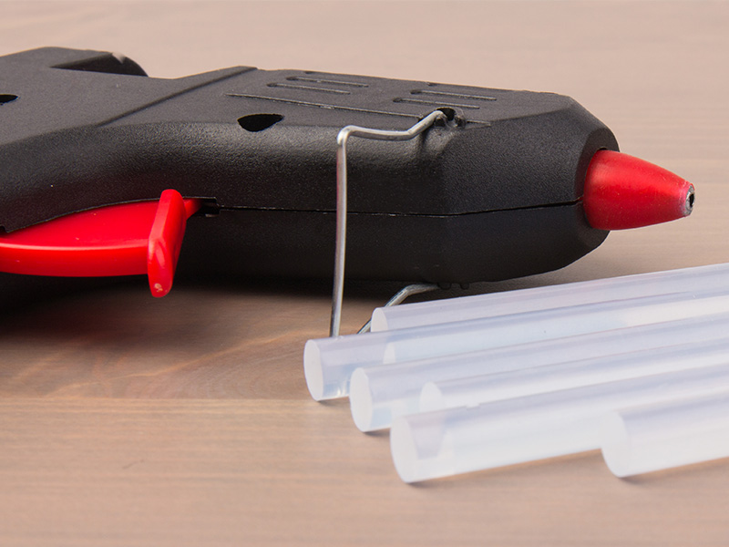 Close-up of a hot glue gun and hot glue sticks made from EBA hot melt adhesives 