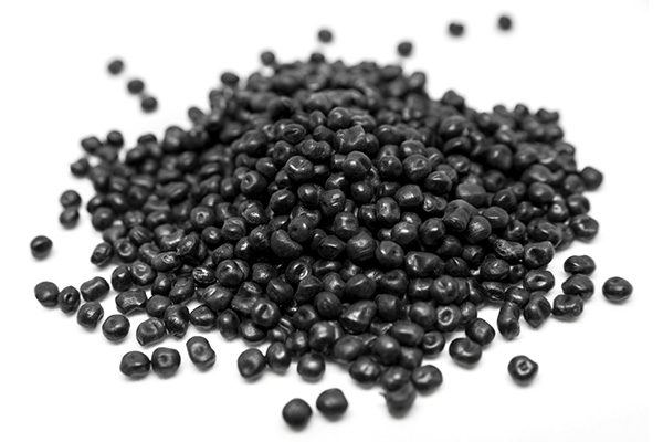 Black plastic granules on a white background