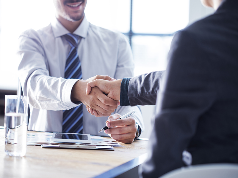 Two people in business attire shaking hands